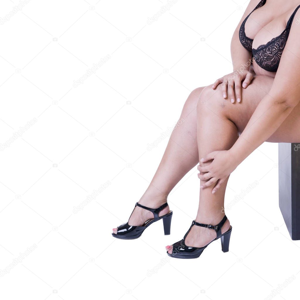 Plus size model in black high heels shoes, xxl woman isolated on white background, legs fatigue