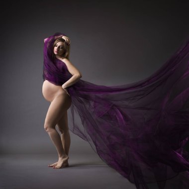 Mor ipek gri arka plan, gebelik çıplak kavramı üzerinde güzel çıplak hamile kadınla