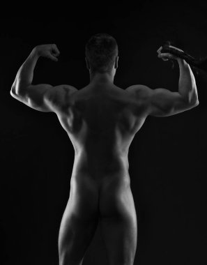 Siyah arka planda, düşük anahtar stüdyo çekim poz yakışıklı kaslı vücut geliştirmeci