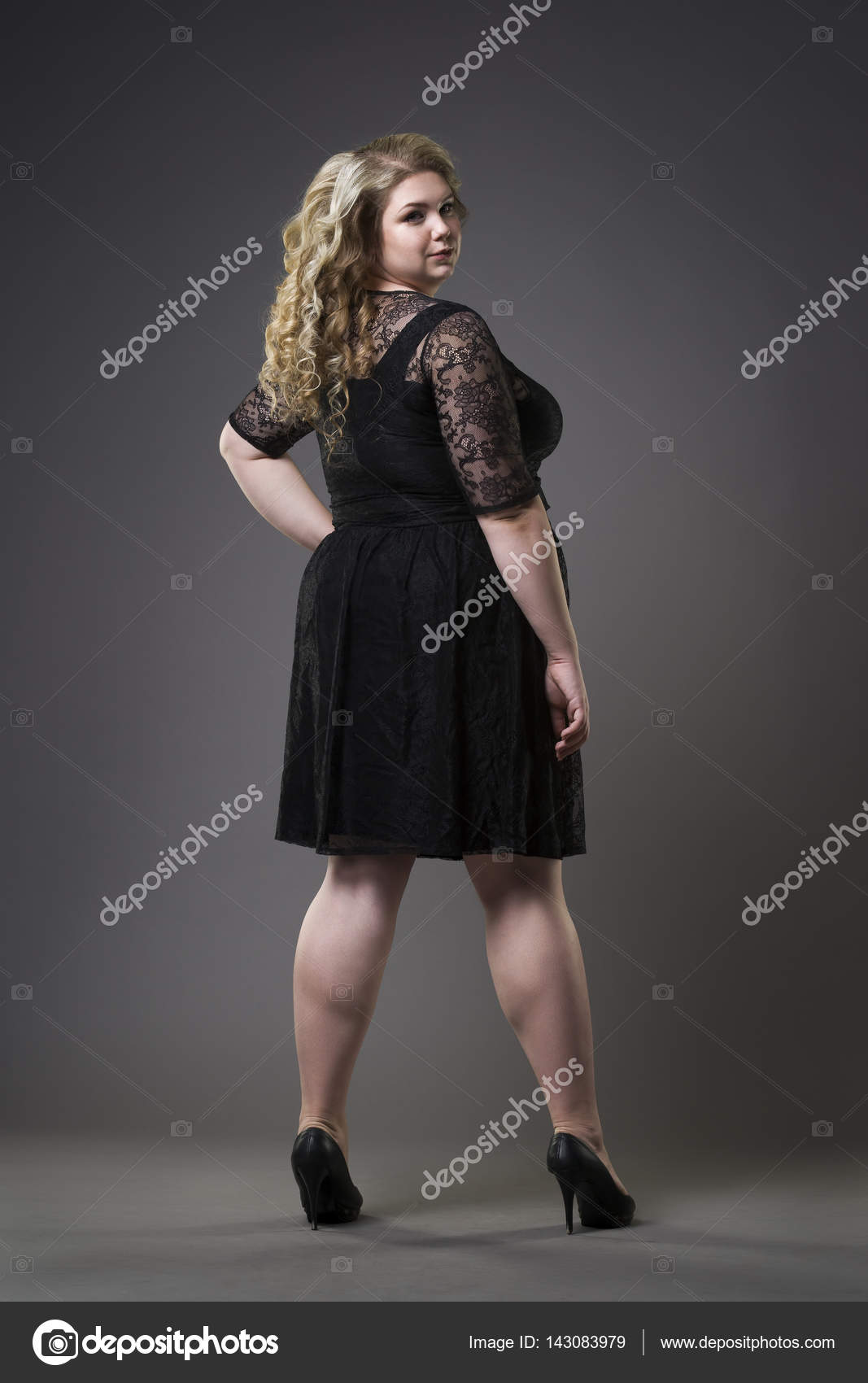 Jovem modelo bonito plus size em preto dres, xxl mulher no fundo estúdio  cinza fotos, imagens de © starast #143083979