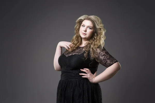Junge schöne Blondine plus Size-Modell in schwarz dres, XL-Frauenporträt auf grauem Studiohintergrund — Stockfoto