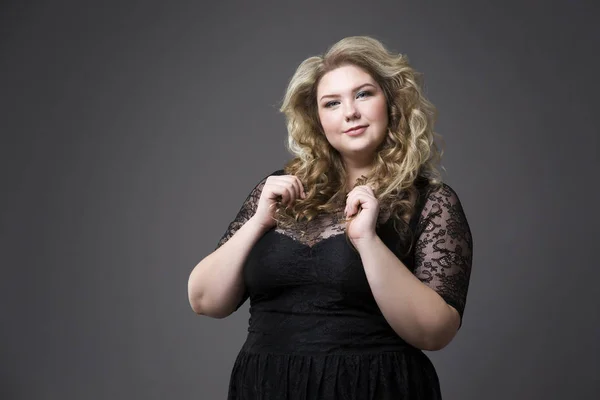 Young beautiful blonde plus size model in black dres, xxl woman portrait on gray studio background — Stock Photo, Image