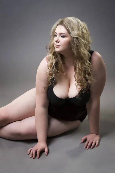 Jovem linda loira plus size modelo com grandes seios naturais em roupa interior, xxl mulher no fundo estúdio cinza — Fotografia de Stock