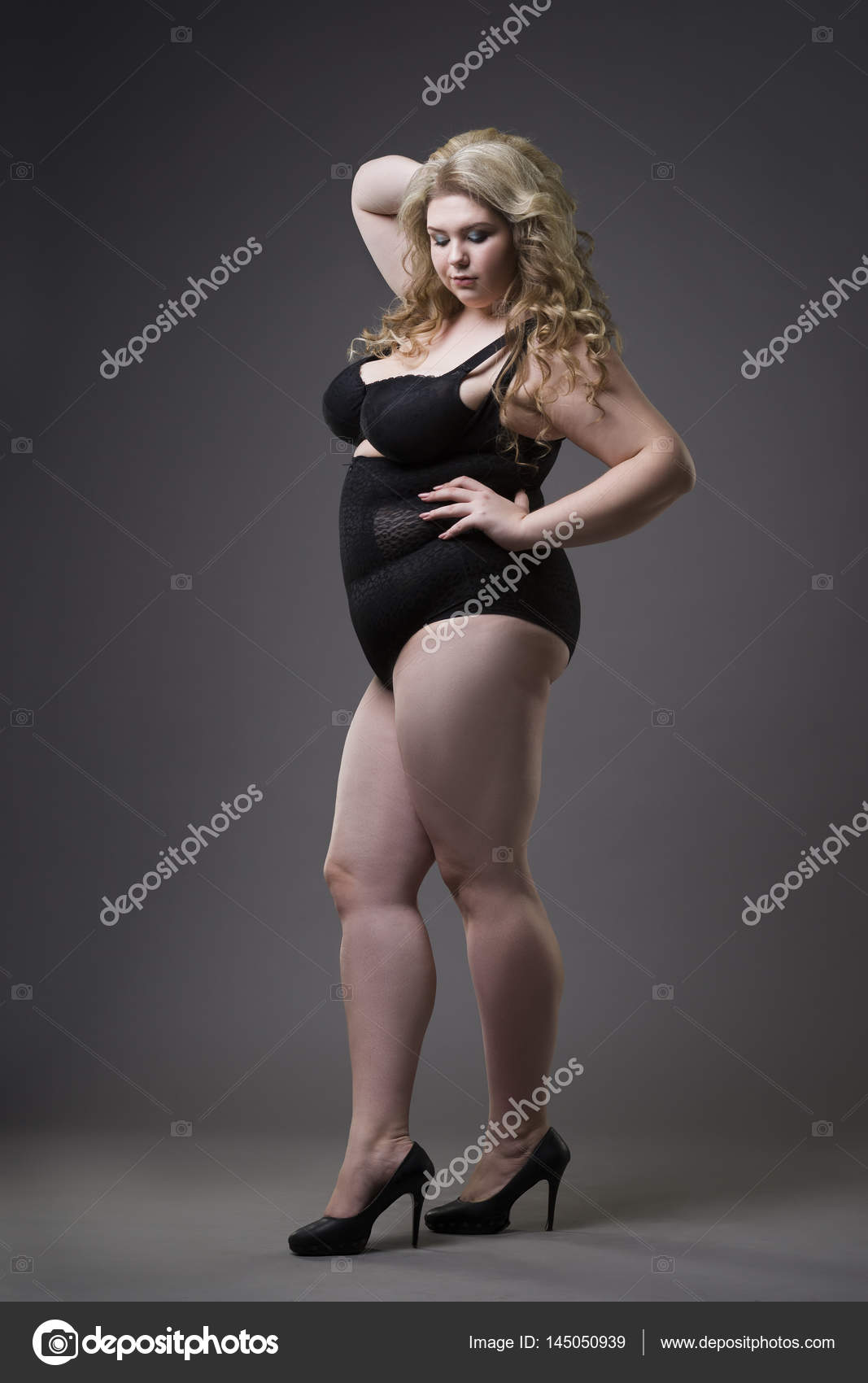 Young beautiful blonde plus size in shapewear, xxl woman in slimming underwear on gray studio background Stock Photo by ©starast 145050939
