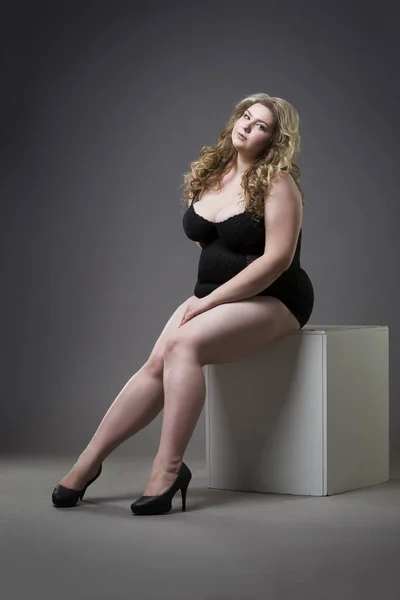 Young beautiful blonde plus size model in shapewear, xxl woman in slimming underwear on gray studio background — Stock Photo, Image