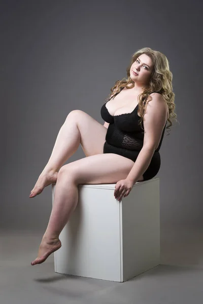 Junge schöne Blondine plus Size-Modell in Shapewear, XL-Frau in schlanker Unterwäsche auf grauem Studiohintergrund — Stockfoto