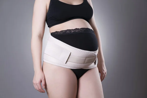 Pregnant woman in black underwear with orthopedic support belt, pregnancy bandage — Stock Photo, Image