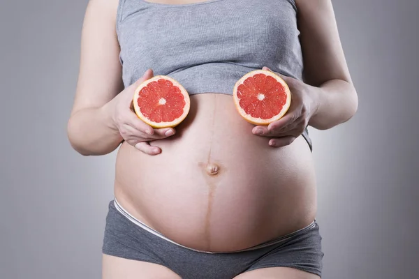 Gebelik ve beslenme - meyveler el üstünde olan hamile kadın gri arka plan, vejetaryen diyet — Stok fotoğraf