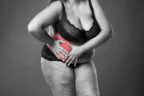 Fat woman with appendicitis attack, abdominal pain, stomach ache, overweight female body on gray background