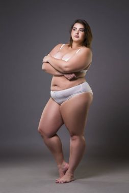 Boyutu moda model iç çamaşırı, gri arka plan üzerinde genç şişman kadın kilolu kadın bedeni
