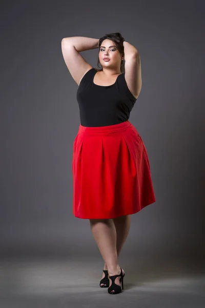 Plus size mode modell i röd kjol, fet kvinna på grå bakgrund, övervikt kvinnliga kroppen — Stockfoto
