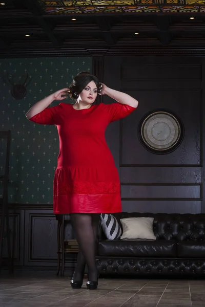 Plus velikost modelka v červené večerní šaty, tlustá žena na luxusní interiér, nadváhou ženské tělo, celovečerní portrét — Stock fotografie