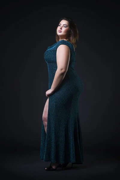 Plus size fashion model in green evening dress, fat woman on black background, overweight female body — Stock Photo, Image
