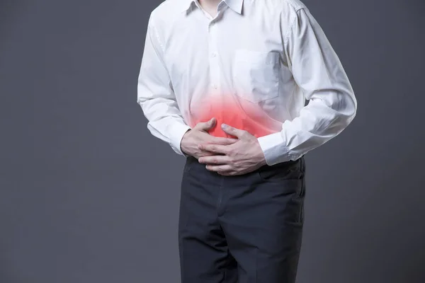 Man met buikpijn, maagpijn op grijze achtergrond — Stockfoto