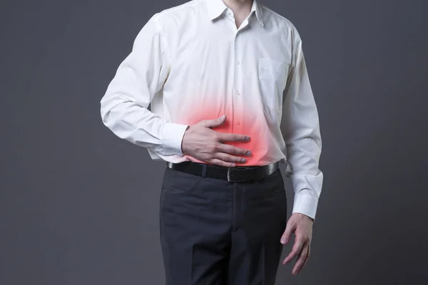 Karın ağrısı, mide ağrısı gri arka plan üzerinde olan adam — Stok fotoğraf