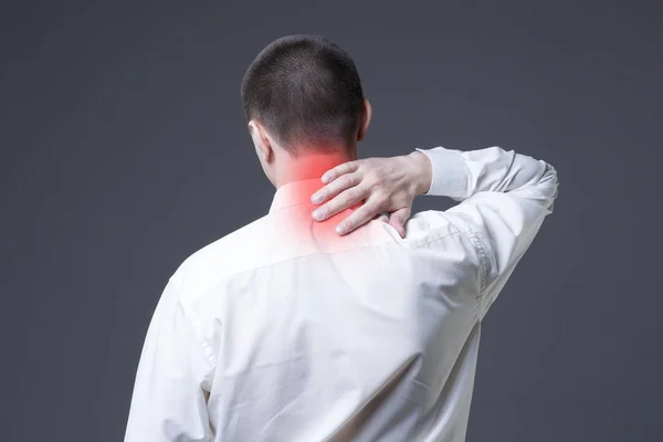 Nackenschmerzen, Mann mit Rückenschmerzen auf grauem Hintergrund — Stockfoto