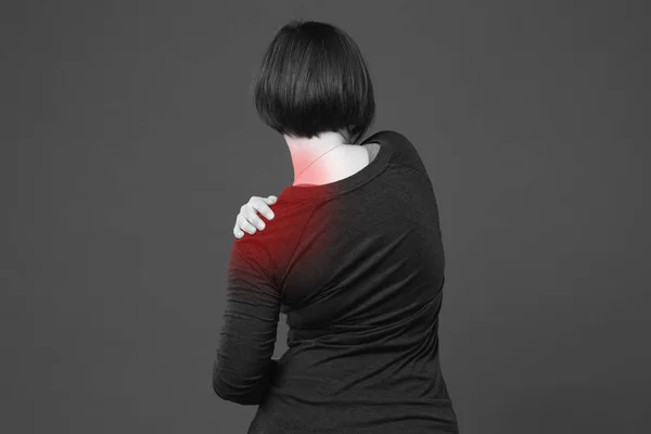 Woman with pain in shoulder on gray background — Stock Photo, Image