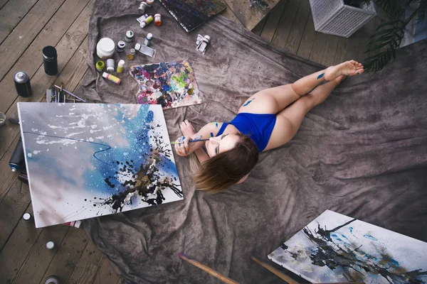 Молодая художница рисует абстрактную картину в студии, красивый сексуальный женский портрет — стоковое фото
