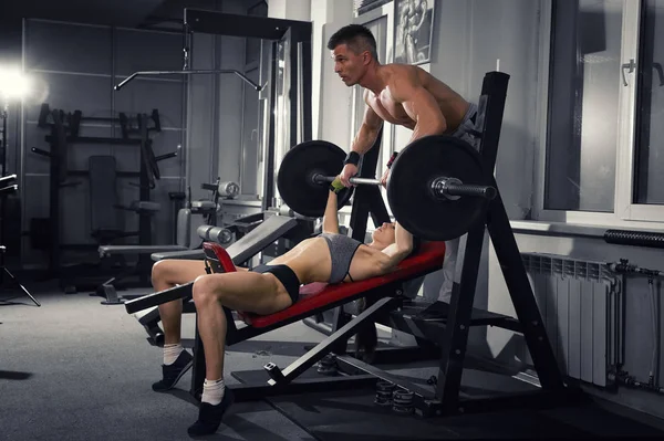 Sexy meisje de fitnesstraining met barbell in de sportschool, vrouw en man in de sport dragen met perfecte gespierd lichaam — Stockfoto