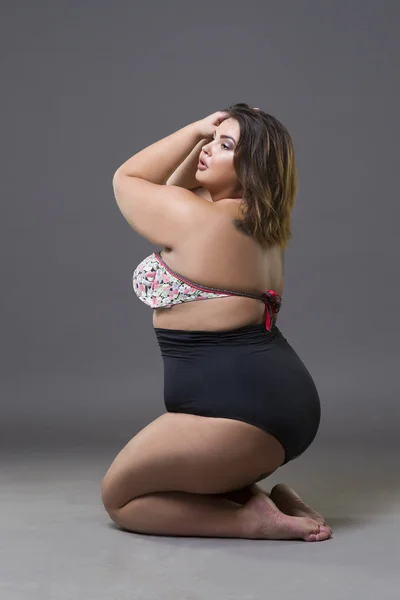 Modelo de moda de talla grande en traje de baño sexy, mujer gorda joven sobre fondo gris, cuerpo femenino con sobrepeso —  Fotos de Stock