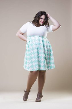 Artı günlük kıyafetlerle manken boy, bej renkli stüdyo arka planda şişman kadın, şişman kadın vücudu.