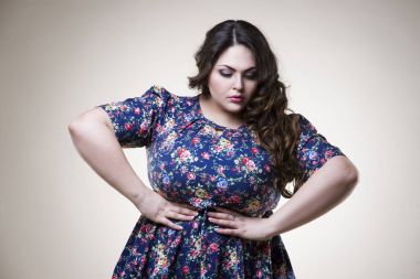 Artı boyutu moda model içinde rahat kıyafetler, bej renkli arka plan üzerinde şişman kadın kilolu kadın bedeni