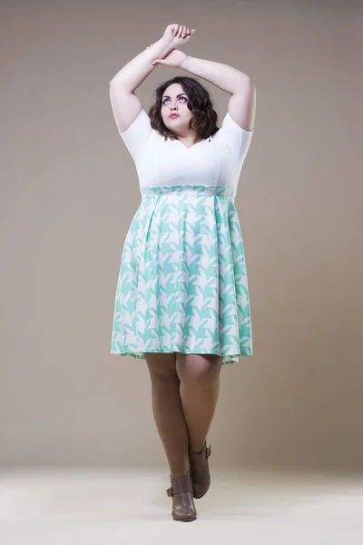 Модель plus size в повседневной одежде, толстая женщина на бежевом фоне студии, избыточный вес женского тела — стоковое фото