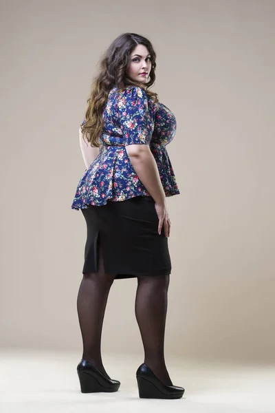 Модель plus size в повседневной одежде, толстая женщина на бежевом фоне студии, избыточный вес женского тела — стоковое фото