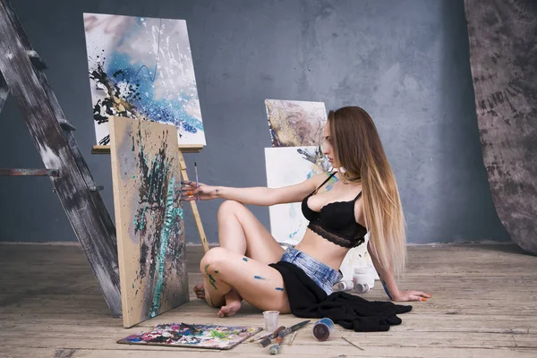 Young female artist painting abstract picture in studio, beautiful sexy woman portrait — Stock Photo, Image