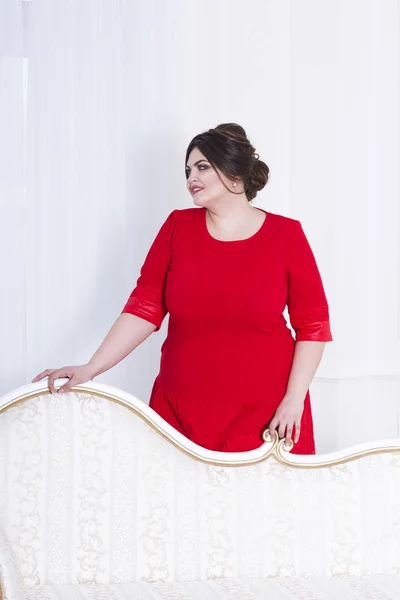 Модель plus size в красном вечернем платье, толстая женщина на роскошном интерьере — стоковое фото