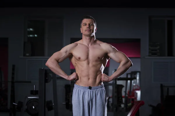 Fisiculturista posando no ginásio, corpo masculino muscular perfeito — Fotografia de Stock