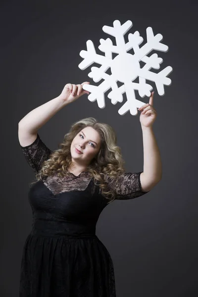 Plus Size Frau in schwarzem Dres mit Schneeflocke auf grauem Hintergrund — Stockfoto