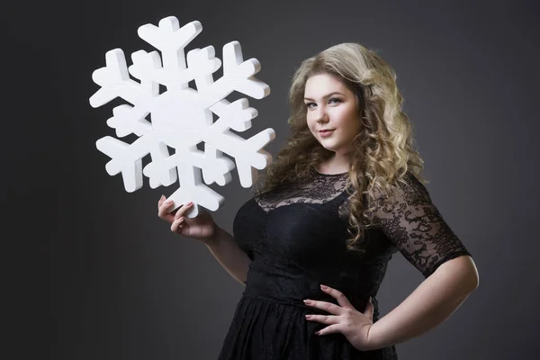 Plus Size Frau in schwarzem Dres mit Schneeflocke auf grauem Hintergrund — Stockfoto