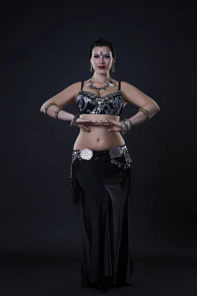 Kobiet wykonuje taniec brzucha w etniczne sukienka na czarnym tle — Zdjęcie stockowe