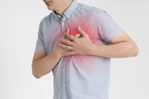 Heart attack, man with chest pain on gray background