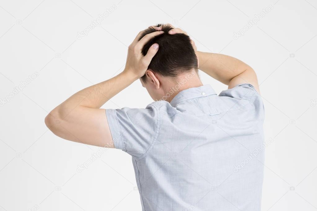 Headache and migraine, man with head pain on gray background