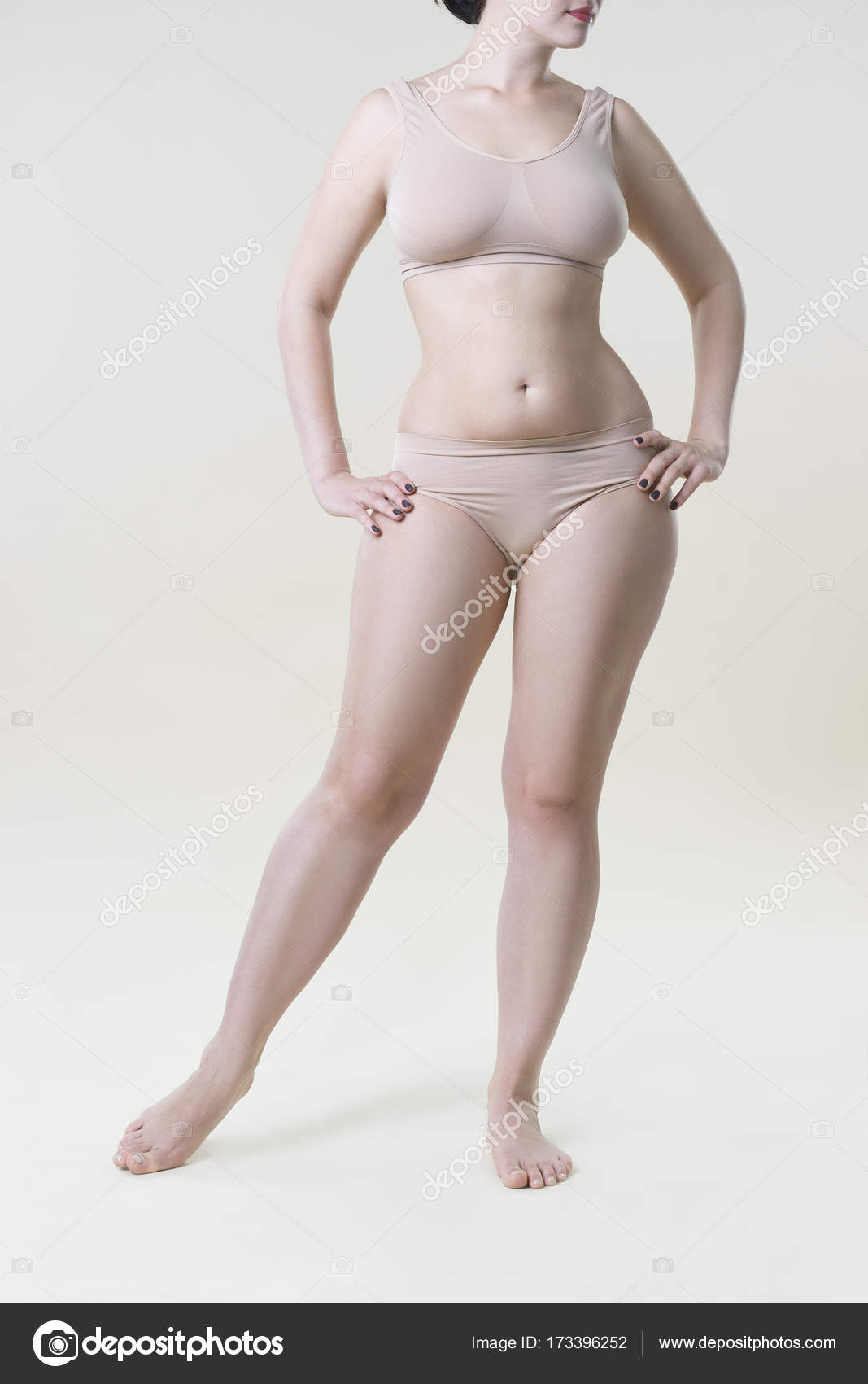 Woman in beige underwear on studio background, cellulite on female