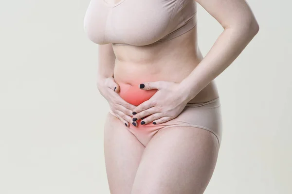 Vrouw met buikpijn, maagpijn op beige achtergrond — Stockfoto