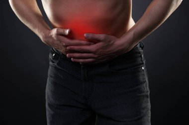 Karın ağrısı, mide ağrısı siyah arka plan üzerine olan adam