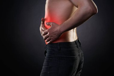 Man with abdominal pain, stomach ache on black background clipart
