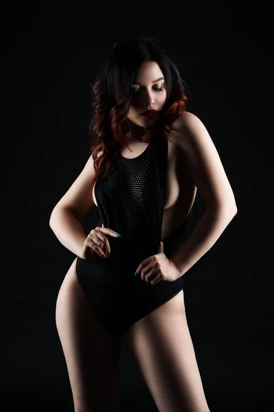 Mulher sexy bonita em bodysuit posando no fundo preto, baixo tiro estúdio chave — Fotografia de Stock