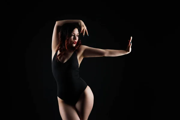 Schöne sexy Frau im Body posiert auf schwarzem Hintergrund, zurückhaltend Studioaufnahme — Stockfoto