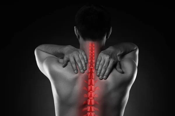 Pain in the spine, a man with backache, injury in the human back and neck