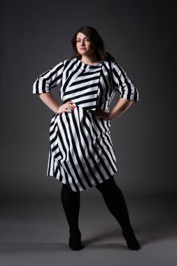 Boyutu moda modeli çizgili elbise, gri arka plan, kilolu kadın bedeni üzerinde kadın şişko