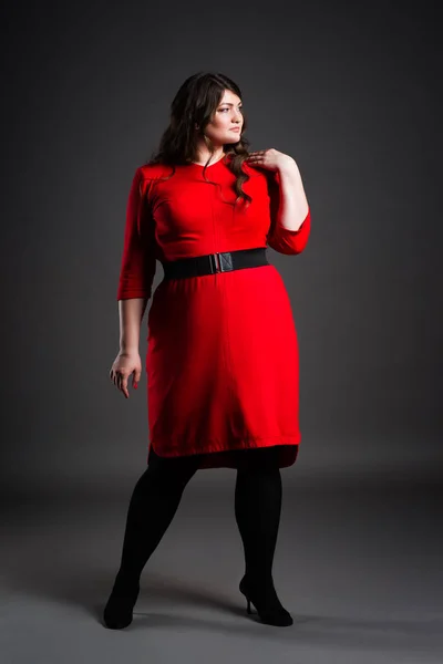 Plus size mode modell i röd klänning, fet kvinna på grå bakgrund, övervikt kvinnliga kroppen — Stockfoto