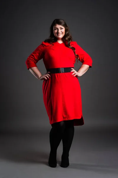 Feliz modelo de moda de talla grande en vestido rojo, mujer gorda sobre fondo gris, cuerpo femenino con sobrepeso —  Fotos de Stock