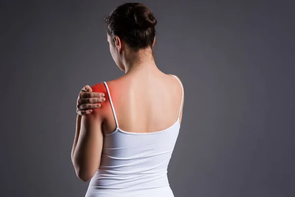 Woman with pain in shoulder on gray background — Stock Photo, Image