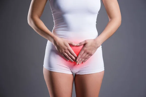 Woman with abdominal pain, stomachache on gray background — Stock Photo, Image