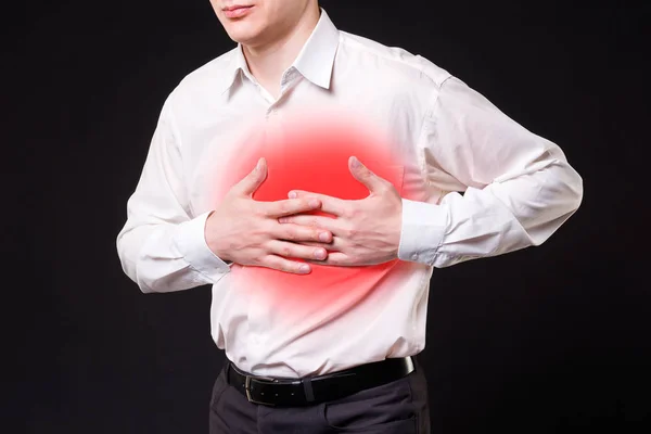 Сердечный приступ, человек с болью в груди на черном фоне — стоковое фото