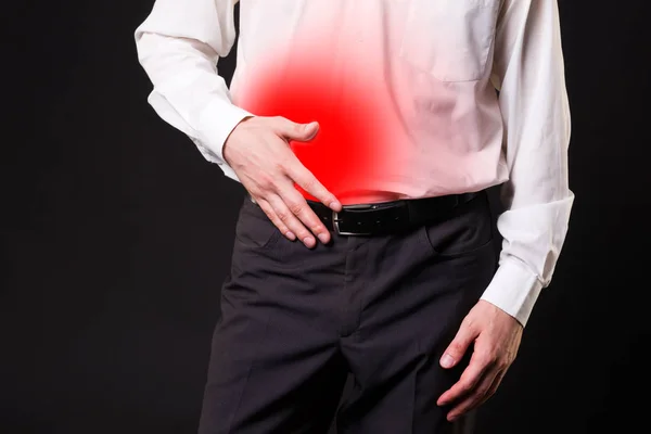 Man with abdominal pain, stomach ache on black background — Stock Photo, Image